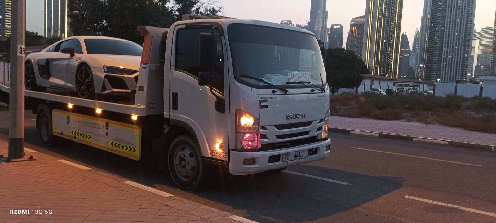 Al Mahra recovery truck carrying a car on a UAE road